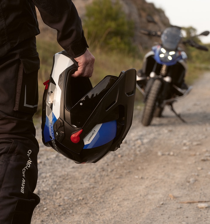 Oseba drži v roki motocikelsko čelado.